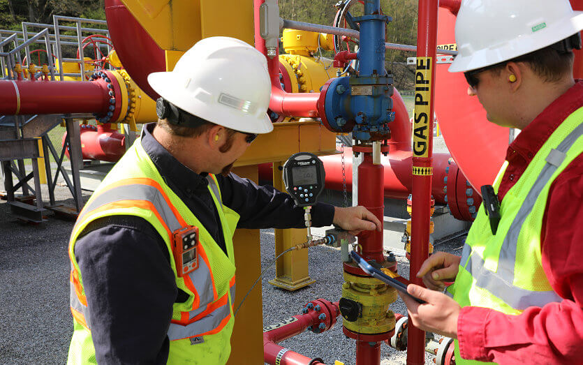 Employees working on meters for pipeline operations
