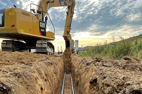 Caterpillar tractor digging trench for pipeline