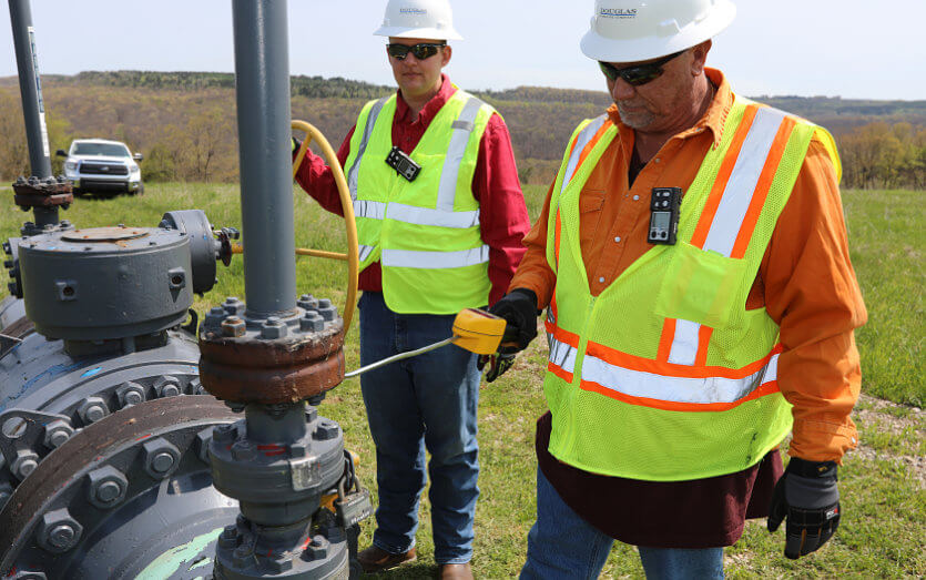 Employees checking for natural gas links during a pipeline regulatory compliance check