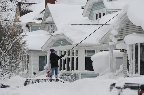 Man removing snow from his house